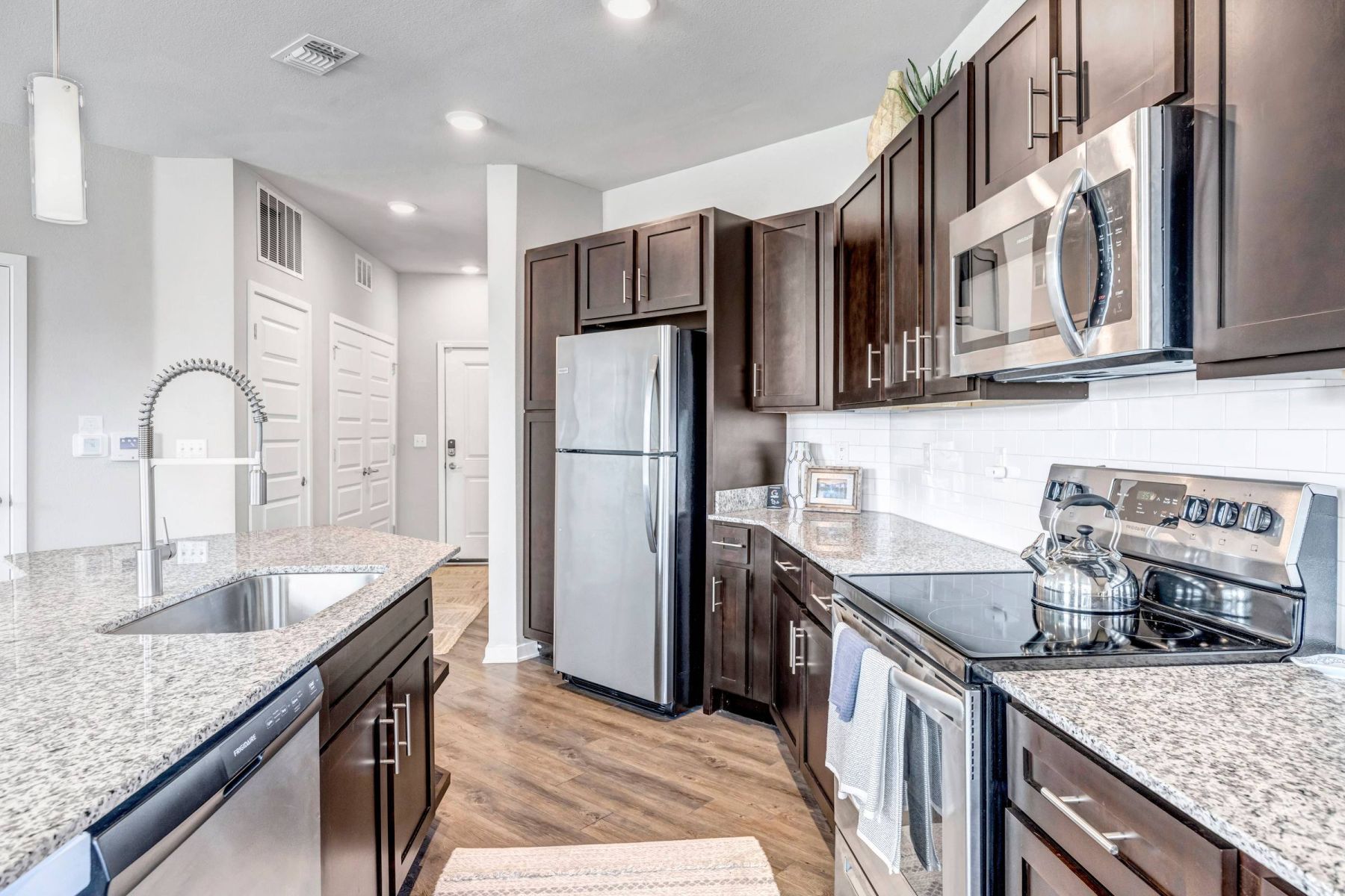 Luxury apartment kitchen with stainless steel appliances, granite countertops, and lots of storage space